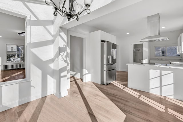 dining room with light hardwood / wood-style floors, radiator heating unit, and a chandelier