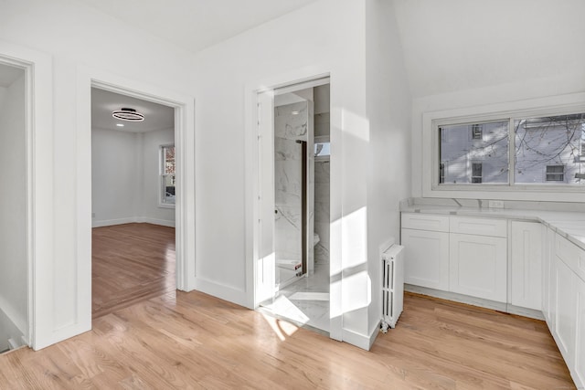 hallway featuring light wood-type flooring and radiator