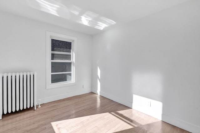 empty room with radiator and light wood-type flooring