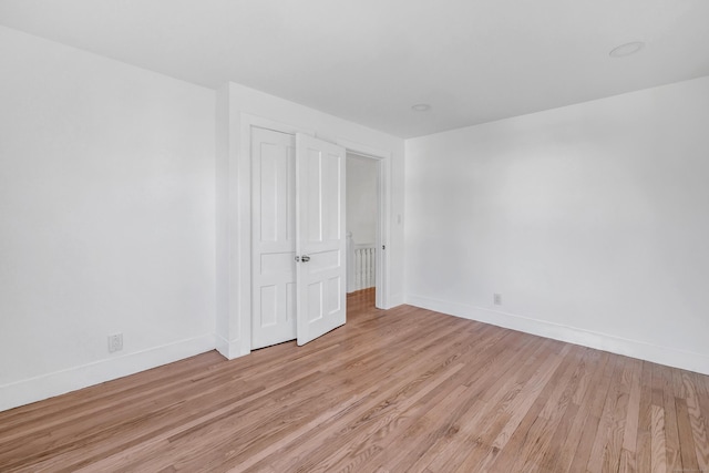 unfurnished bedroom with light hardwood / wood-style floors and a closet