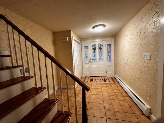 foyer entrance with light tile patterned floors, a textured wall, stairs, a textured ceiling, and a baseboard heating unit