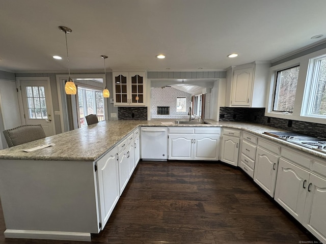 kitchen with tasteful backsplash, dishwasher, dark wood-style flooring, white cabinetry, and a sink