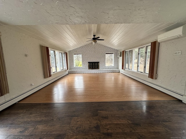 unfurnished living room with a fireplace, lofted ceiling, a textured wall, a wall mounted AC, and a baseboard heating unit