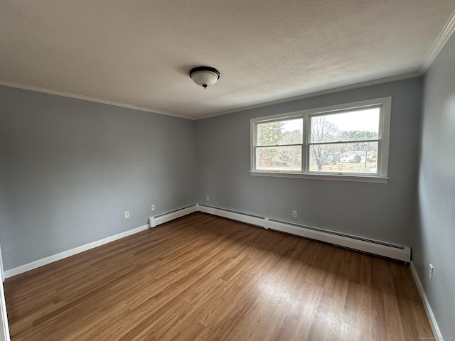 spare room featuring a textured ceiling, baseboards, and wood finished floors