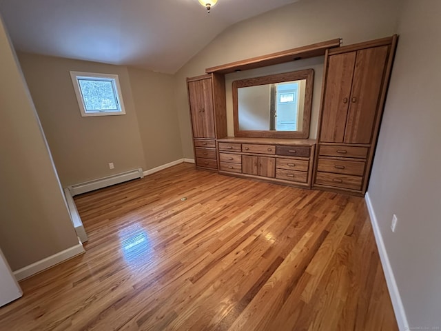 unfurnished bedroom featuring lofted ceiling, light wood-style flooring, a baseboard heating unit, and baseboards