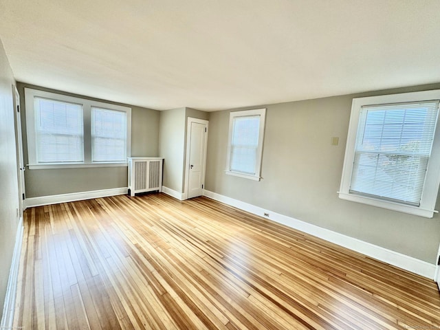 unfurnished room with radiator and light hardwood / wood-style floors