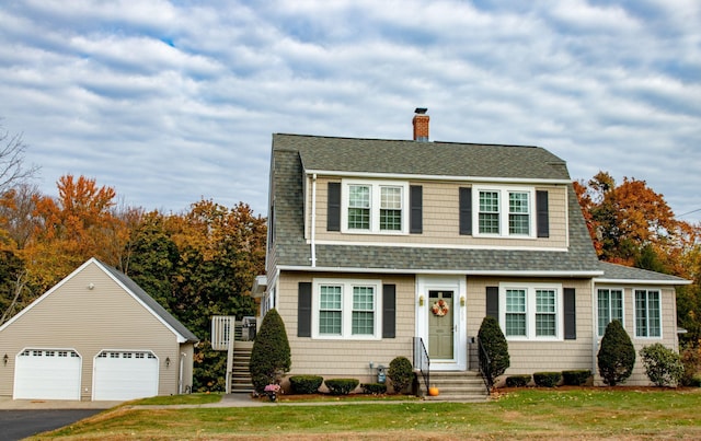 view of front of house with an outdoor structure, a garage, and a front lawn