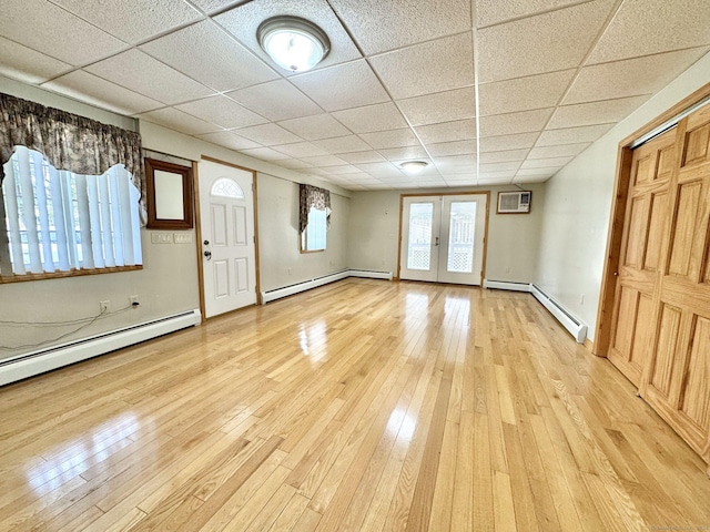 entrance foyer with a baseboard heating unit, a paneled ceiling, and light hardwood / wood-style floors