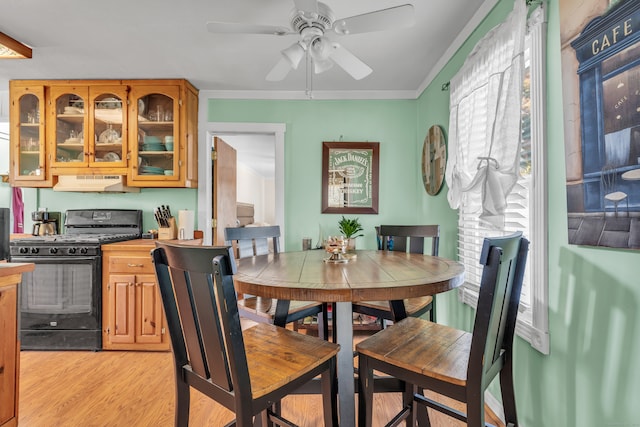 dining room with crown molding, light wood-type flooring, and ceiling fan