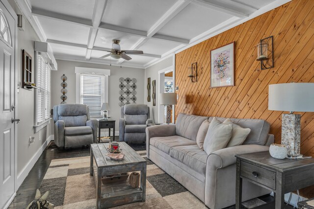 living room featuring wood walls, dark hardwood / wood-style flooring, ceiling fan, coffered ceiling, and beamed ceiling