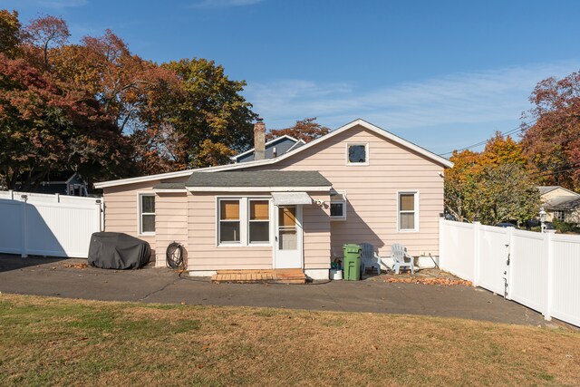 rear view of property with a yard and a patio