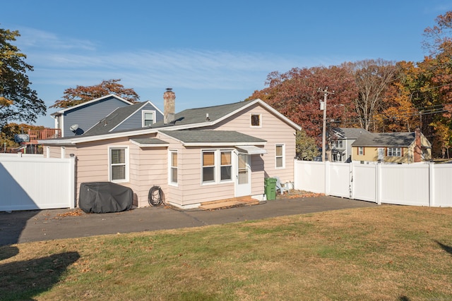 back of property with a patio and a lawn