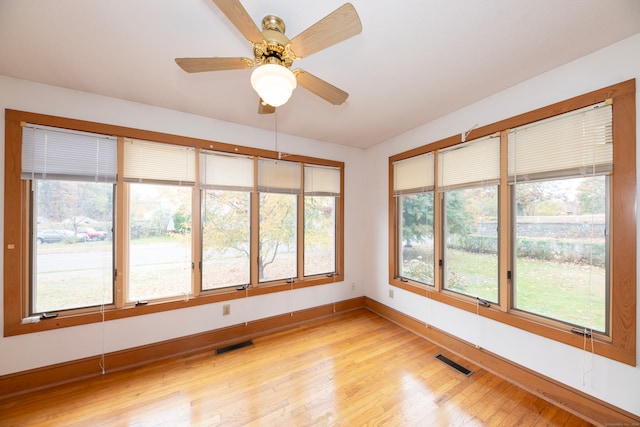 unfurnished sunroom with ceiling fan