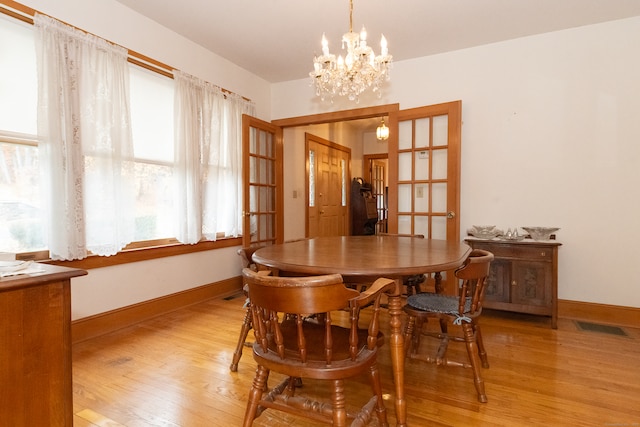 dining area featuring light hardwood / wood-style floors and a chandelier