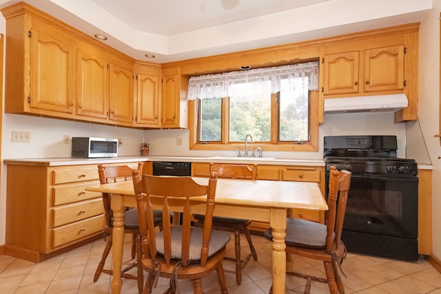 kitchen with light tile patterned flooring, black appliances, sink, and a raised ceiling