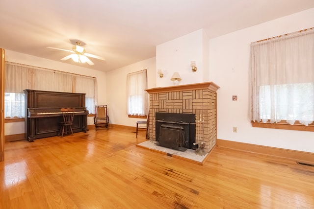 unfurnished living room with ceiling fan, a fireplace, and hardwood / wood-style floors