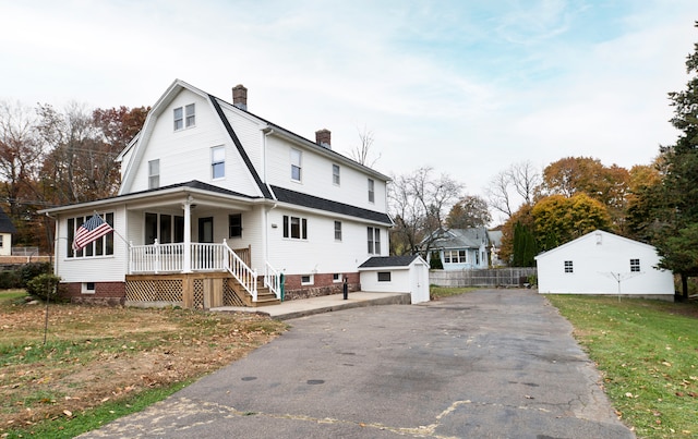 view of front of house with an outdoor structure, covered porch, and a garage