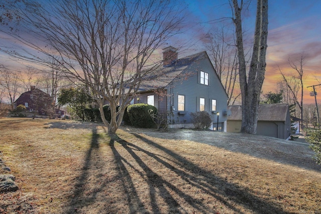 property exterior at dusk with a garage and a lawn