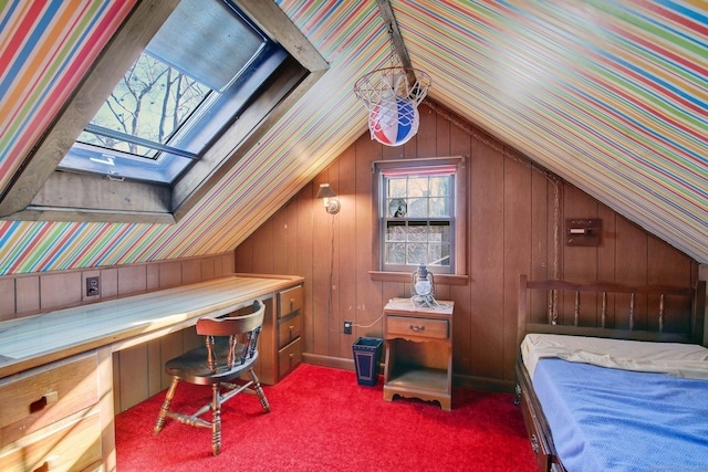 bedroom with wood walls, carpet, and lofted ceiling with skylight