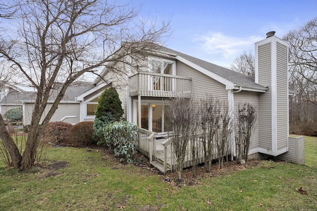 view of side of property featuring a lawn and a balcony