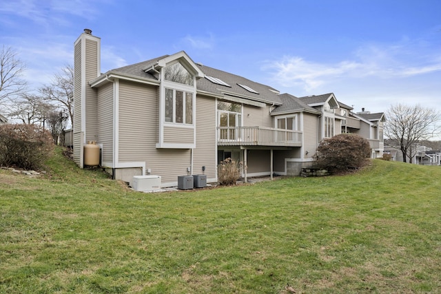 back of property featuring a yard, a wooden deck, and central air condition unit