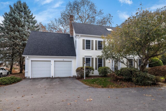 13 Longview Ter Unit 13, Madison, CT 06443 - view of front of house featuring a garage, a chimney, driveway, and roof with shingles