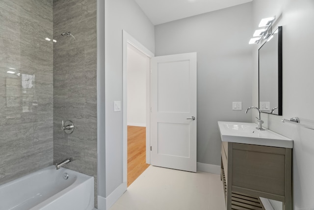 bathroom featuring tiled shower / bath, vanity, and hardwood / wood-style floors