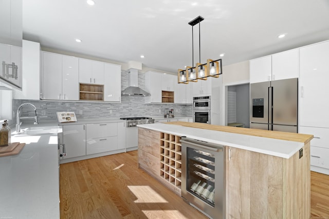 kitchen with a kitchen island, white cabinets, hanging light fixtures, and stainless steel appliances