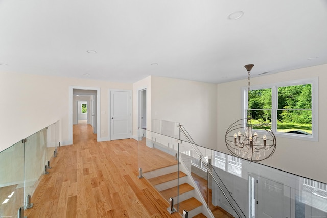 corridor featuring a chandelier and light hardwood / wood-style flooring