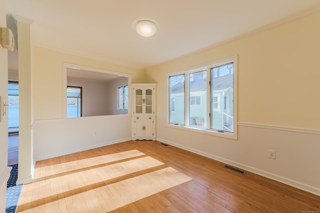 unfurnished room featuring wood-type flooring and ornamental molding