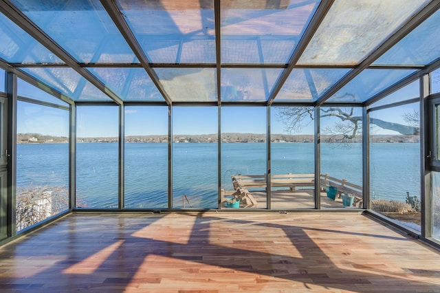 unfurnished sunroom featuring plenty of natural light and a water view