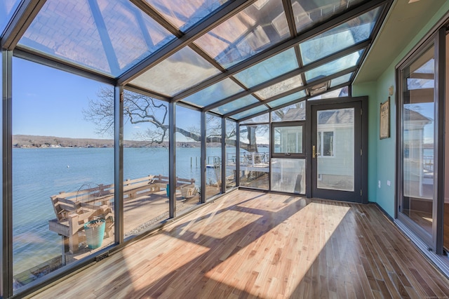 unfurnished sunroom featuring vaulted ceiling and a water view