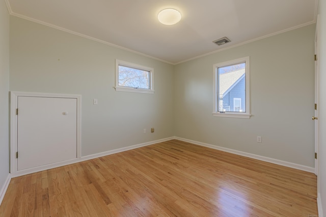 spare room featuring ornamental molding and light wood-type flooring