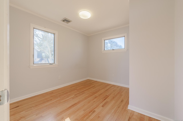 spare room with crown molding and light wood-type flooring