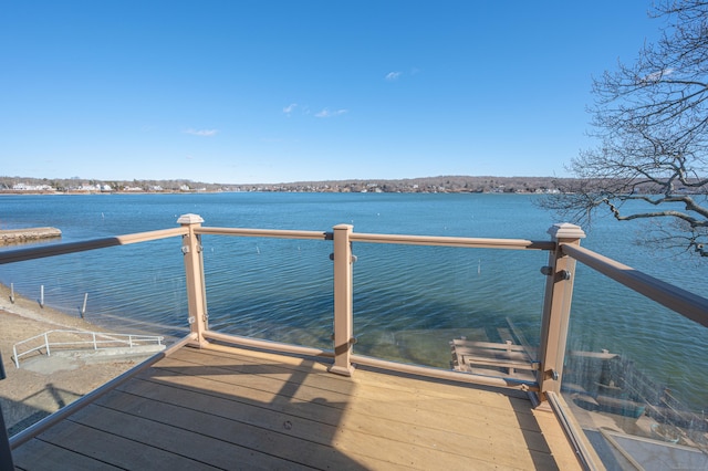 view of dock with a balcony and a water view