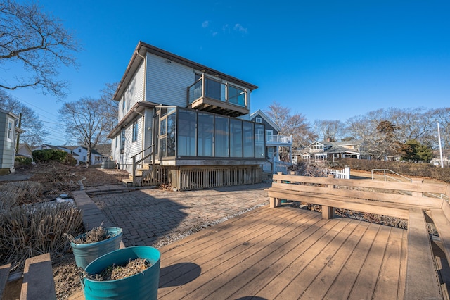 wooden deck with a patio area and a sunroom