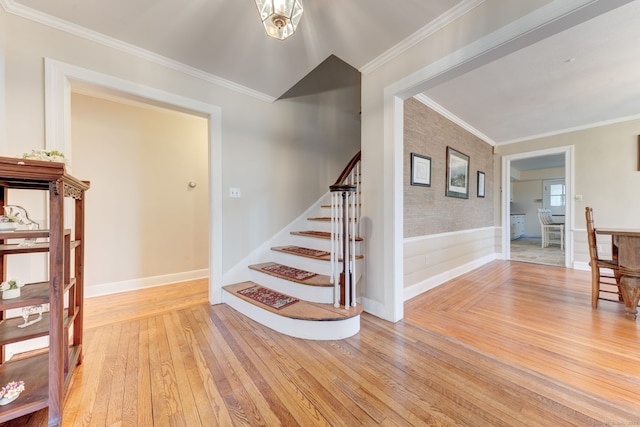 stairway featuring crown molding, baseboards, and hardwood / wood-style floors