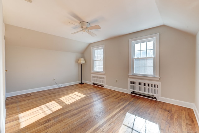 additional living space with radiator heating unit, hardwood / wood-style flooring, and baseboards