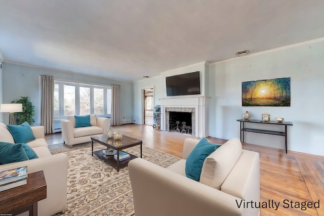 living area featuring light wood-style floors, visible vents, crown molding, and a fireplace