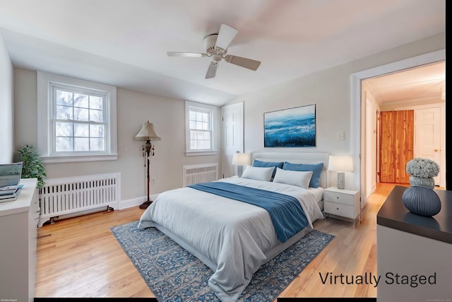 bedroom with a ceiling fan, light wood-type flooring, and radiator