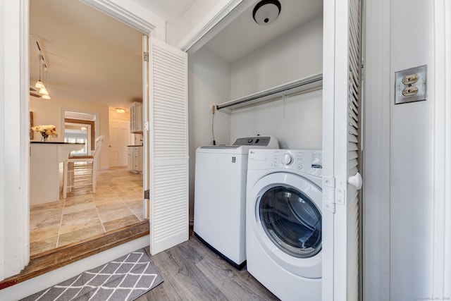 laundry room with laundry area, washer and clothes dryer, and wood finished floors