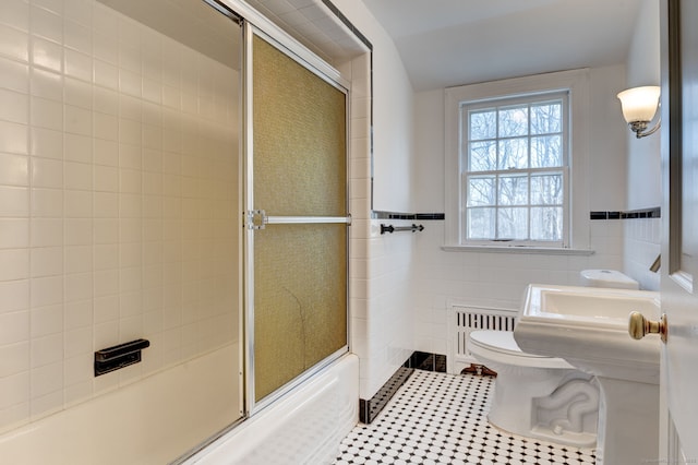 full bath with tile walls, radiator, toilet, combined bath / shower with glass door, and tile patterned flooring