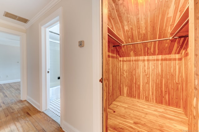 interior space with crown molding, visible vents, hardwood / wood-style floors, wooden ceiling, and baseboards