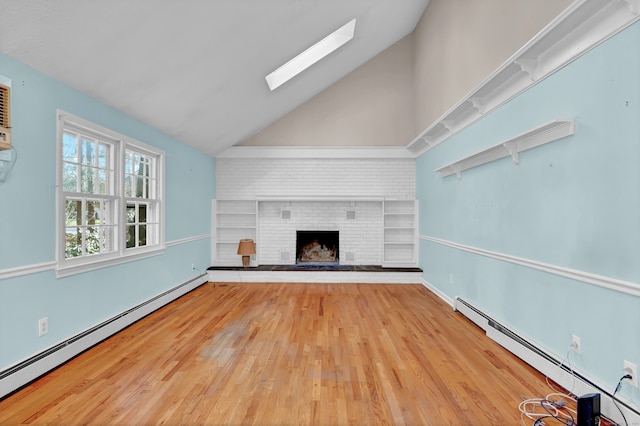 unfurnished living room featuring baseboard heating, hardwood / wood-style flooring, high vaulted ceiling, and a brick fireplace