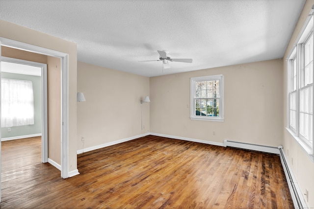 spare room featuring a textured ceiling, a baseboard heating unit, hardwood / wood-style flooring, and ceiling fan