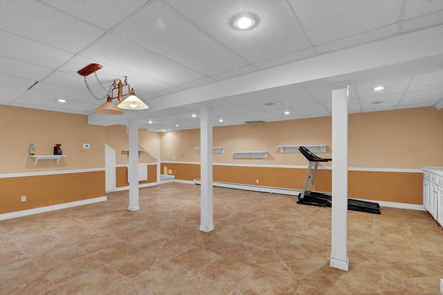 workout room with a paneled ceiling and light tile patterned flooring