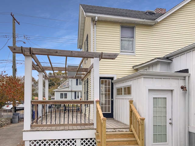 back of property featuring a wooden deck and a pergola