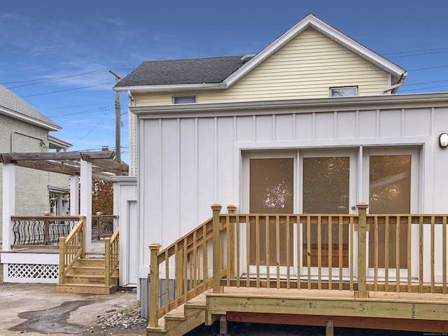 rear view of house with a deck and a pergola