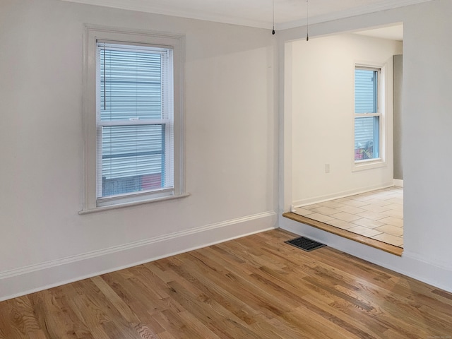 unfurnished room featuring hardwood / wood-style flooring and ornamental molding