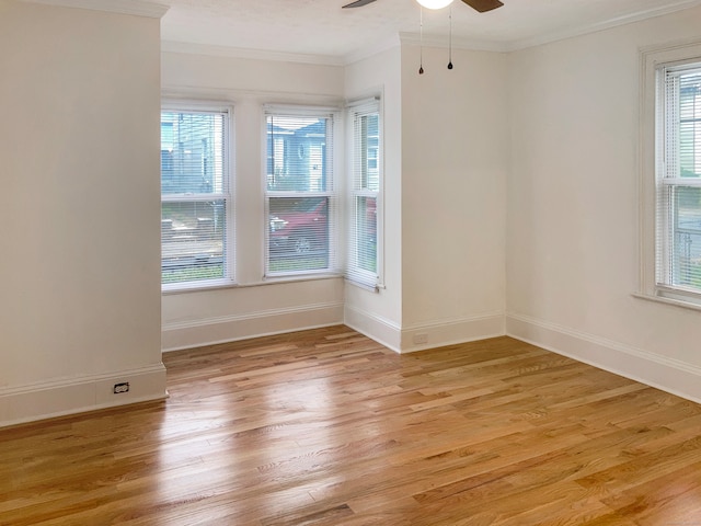 spare room featuring crown molding, light wood-type flooring, and ceiling fan